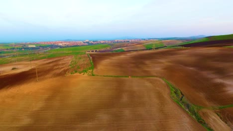 Drohnen-Luftaufnahme-Von-Gepflügten-Landwirtschaftlichen-Flächen-Bei-Sonnenuntergang