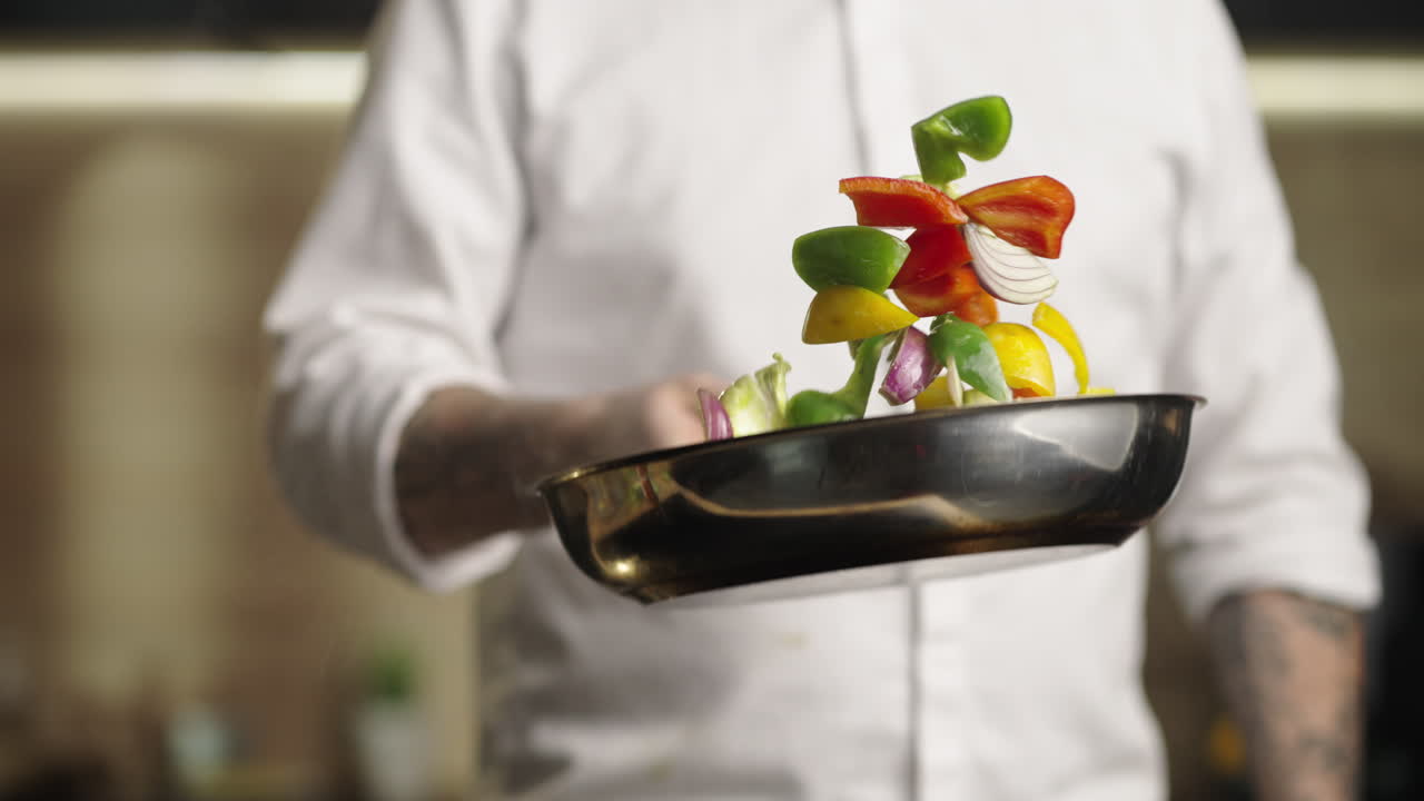 chef cocinando verduras en una sartén