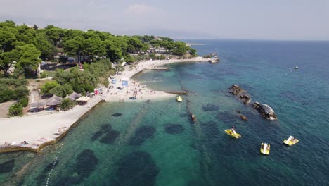 Croatia-Aerial:-Ovčice-Beach,-Split---Crystal-waters,-pebbled-shores,-and-water-activities