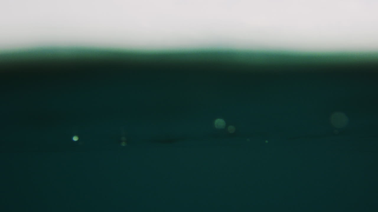 Lucid water flows and bounces at surface as ocean wave crashes empty with vortext texture spray