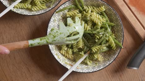 female cook hand preparing a dish of vegan pasta al pesto slow motion 2x 4k