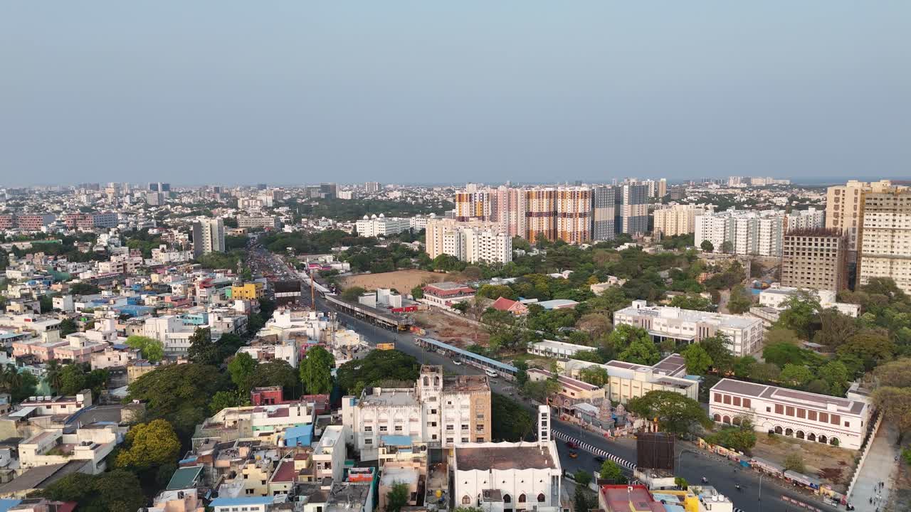 panoramic aerial view of a varied cityscape. a mix of low-rise and high-rise buildings, with several tall apartment complexes dominating the skyline. In the foreground, you can see older buildings