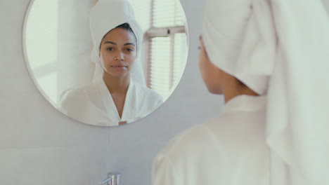 woman looking at herself in the bathroom mirror