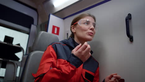 female paramedic sitting in emergency vehicle