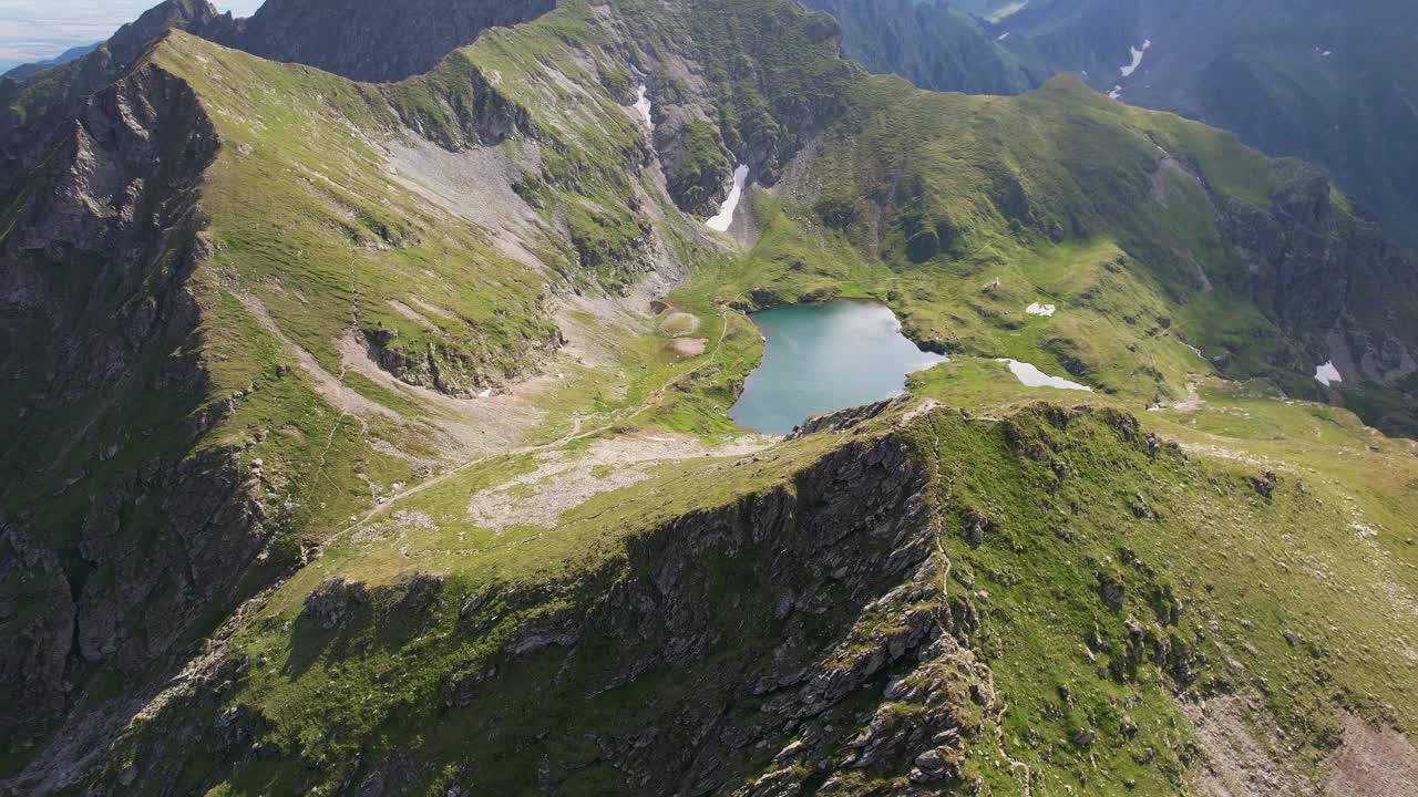 serena vista aérea del lago capra ubicado en las exuberantes montañas fagaras, rumania, bajo cielos despejados