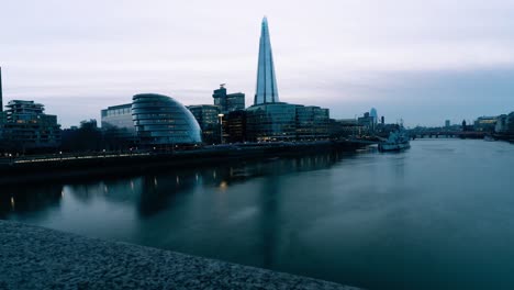 Zeitraffer-Des-Rathauses-In-London,-Großbritannien,-Während-Die-Nacht-Hereinbricht-Und-Boote-Auf-Der-Themse-Fahren