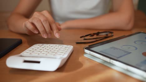 slow motion scene of accountant businesswoman pressing on calculator at office desk to estimating or forecast about business marketing and growth concept