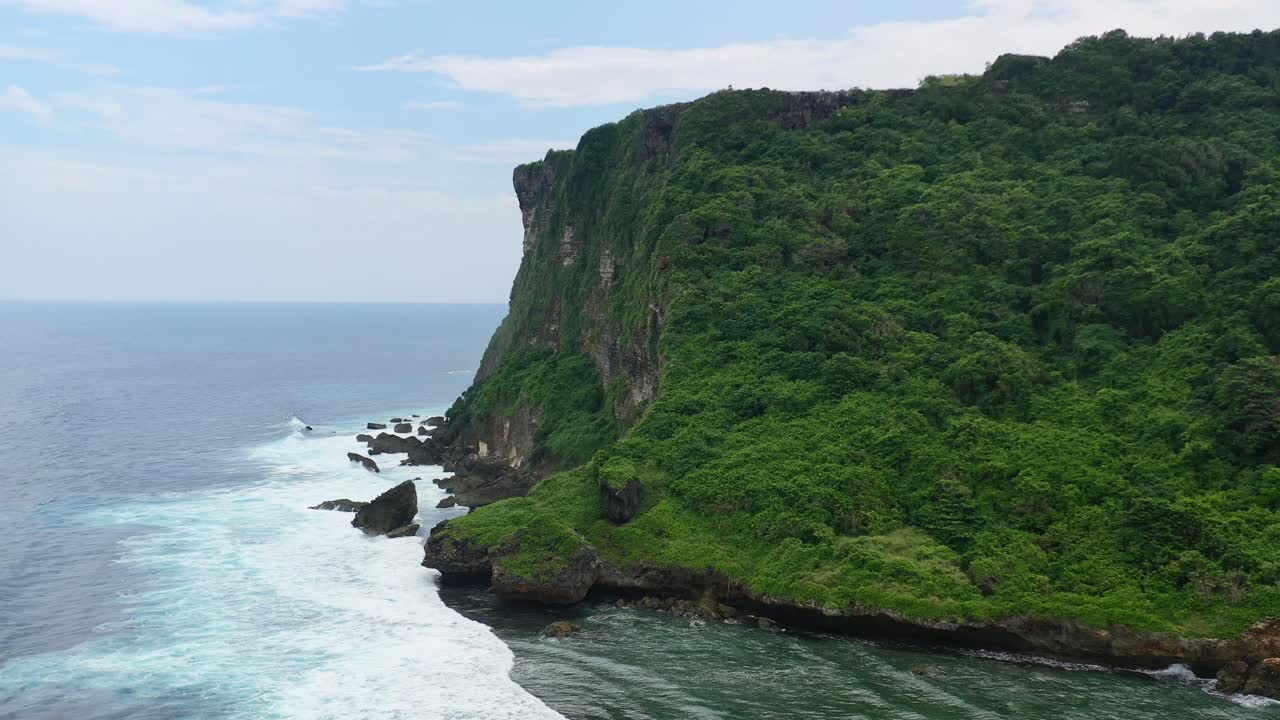 altos acantilados de montaña de uluwatu en bali con olas oceánicas rompiendo en rocas, antena