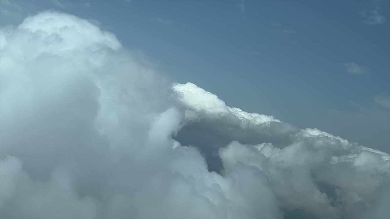 An unique pilot&rsquo;s point of view while flying in a jet across a sky with some tiny cumulus clouds