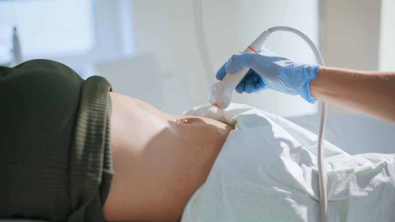 Close de um médico examinando uma gravidez por ultrassom em uma clínica. Ginecologista examinando