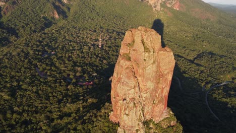 Golden-hour-aerial:-Rock-tower-casts-evening-shadow-on-Bolivia-forest