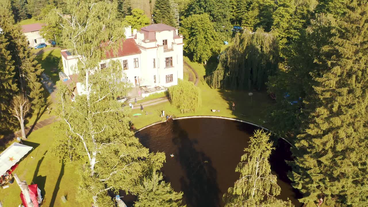 화창한 날 영광스러운 나무로 둘러싸인 하얀 숲 빌라의 멋진 드론 전망 - 공중 촬영