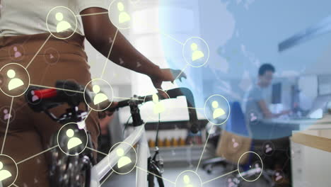 animation of globe and social media icons over diverse business people with bicycle in office
