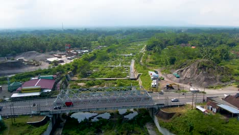 kali putih river bridge and dry riverbed overgrown by greenery aerial view