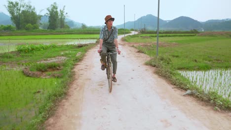 View-of-a-farmer-cycling-while-going-to-his-field-from-home-at-Lang-Son-city,-Vietnam-at-daytime