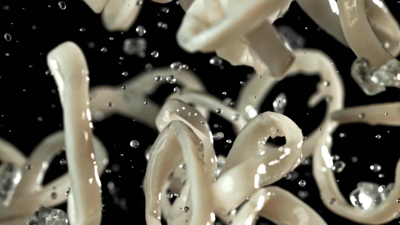Fresh Calamari Rings Falling with Water Droplets in Slow Motion
