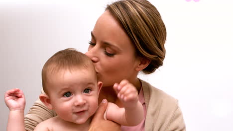 madre sosteniendo y besando a su bebé