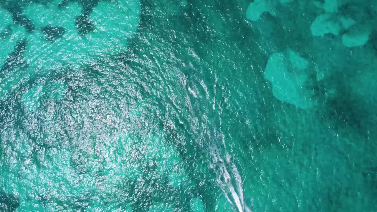 Bird-eye aerial over turquoise blue waters of the Caribbean Sea, near Cancun's hotel zone