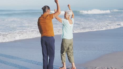 Senior-Caucasian-couple-dancing-at-the-beach