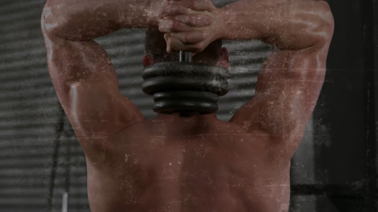 Shirtless man holding dumbbell high, lowering and pressing for fitness triceps, grime overlay