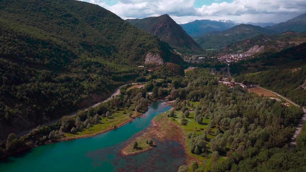 imágenes aéreas horizontales de 4k de un lago en un entorno natural verde con montañas y un pueblo