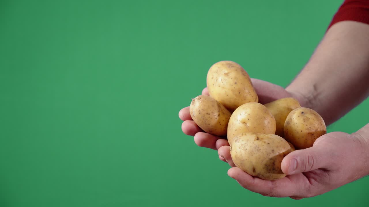 manos masculinas con patatas sin pelar.