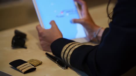 unrecognizable female pilot preparing flight documentation on a tablet