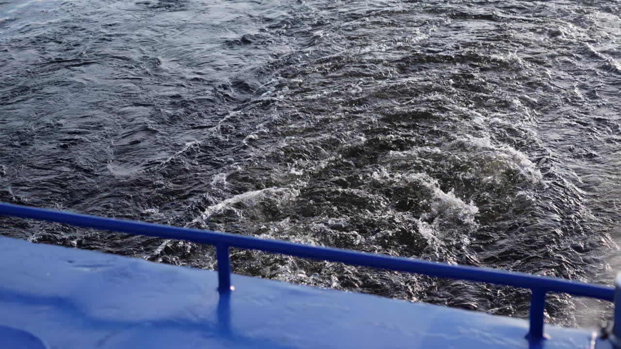 Turbulent Water Wake Behind a Blue Boat
