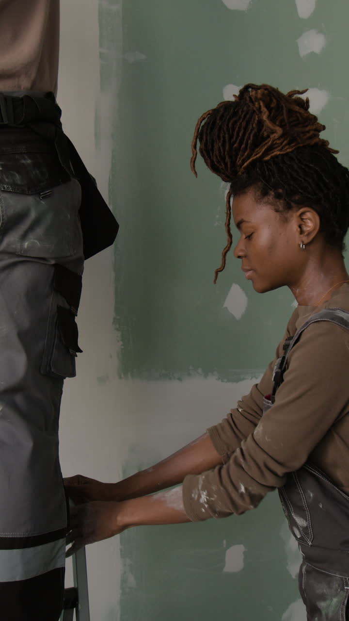 Construction worker using a level on drywall