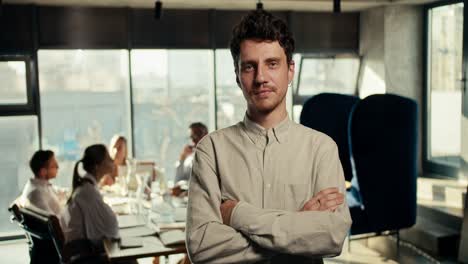 portrait of a serious male office worker in a white shirt who folded his arms on his chest and looks at the camera