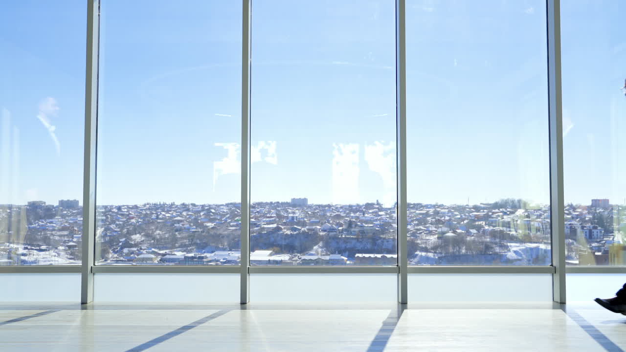 Business meeting indoors. Businessmen in suits greeting each other against large office windows on the background of a city.