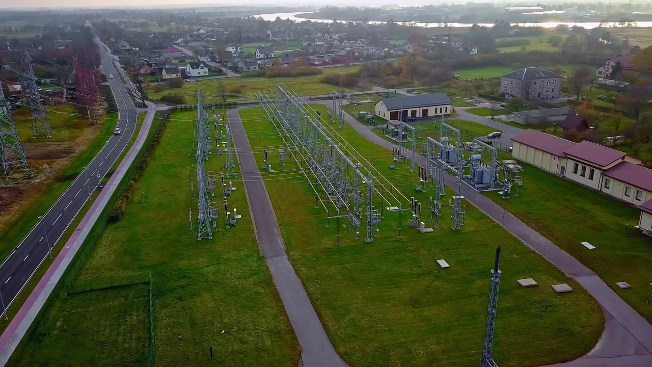 воздушная панель, показывающая электрические провода на траве и машину, проходящую по дороге в сельском городе