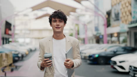 man with coffee and laptop in the city