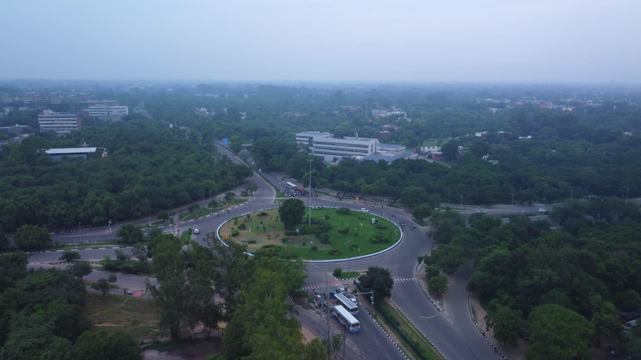 tomada de avión no tripulado de la rotonda de tribune chowk rodeada de árboles verdes, edificio de la oficina del editor del periódico tribune en la vista, chandigarh