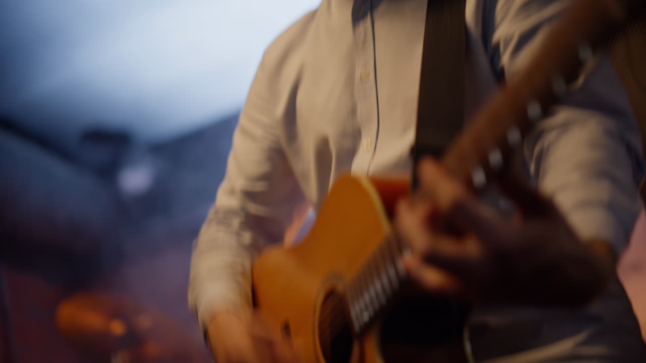 Musicista ispirato che suona la chitarra con una rock band sul palco di un nightclub, primo piano