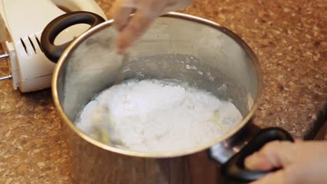 pouring boiling water into a saucepan and mixing with flour and raw eggs