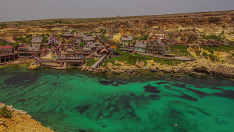 un video de time-lapse visualmente cautivador muestra el encantador parque temático de la aldea de popeye, adornado con un pintoresco lago verde y casas encantadoras ubicadas con gracia alrededor de sus pintorescas orillas.