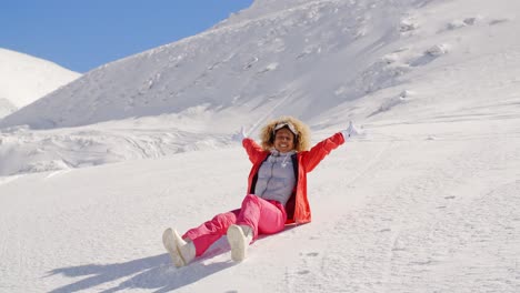 Jubelnde-Frau-Rutscht-Einen-Schneebedeckten-Hügel-Hinunter