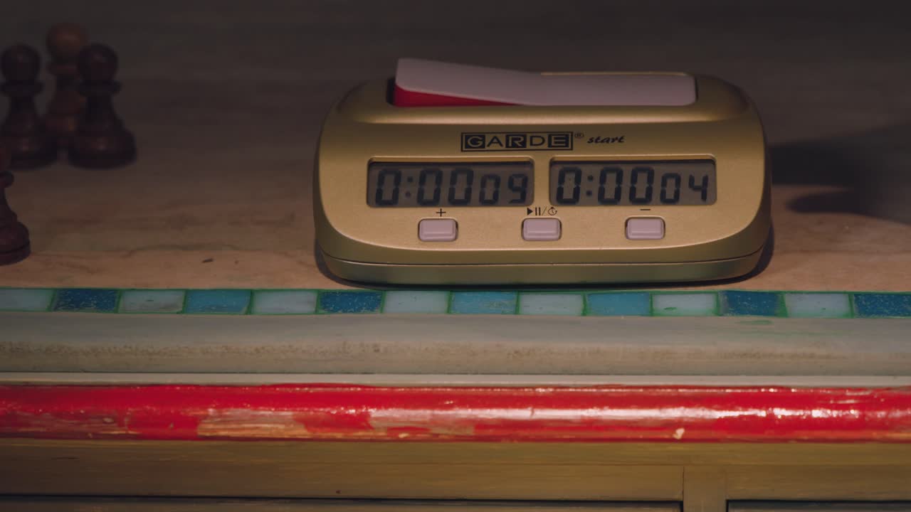 Close-up of a hand interacting with a chess clock
