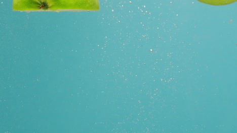 green apples splashing underwater