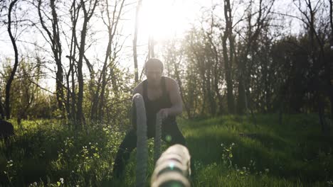 Ein-Gutaussehender-Kerl-Trainiert-In-Einem-Park-Zwischen-Dünnen-Bäumen.-Crossfit.-Schwinge-Die-Seile.-Extrem-Nahe-Aufnahmen-Von-Seilen.-Im-Hintergrund-Scheint-Die-Sonne