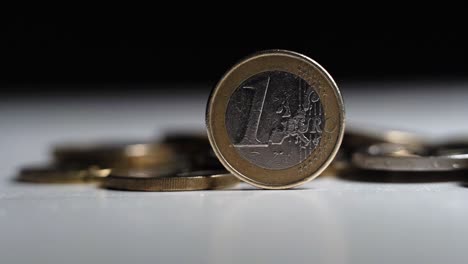 revealing shot of euro coins, movement from left to right, light changing