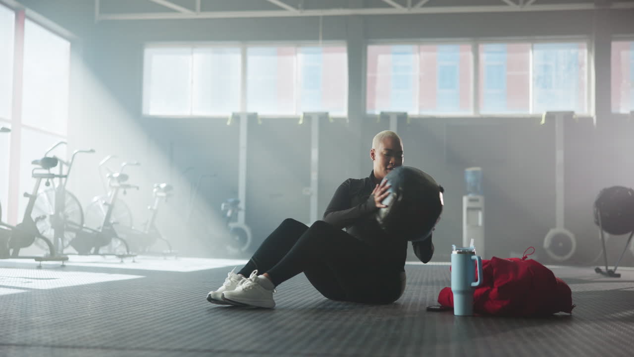 Woman exercising with medicine ball in a gym