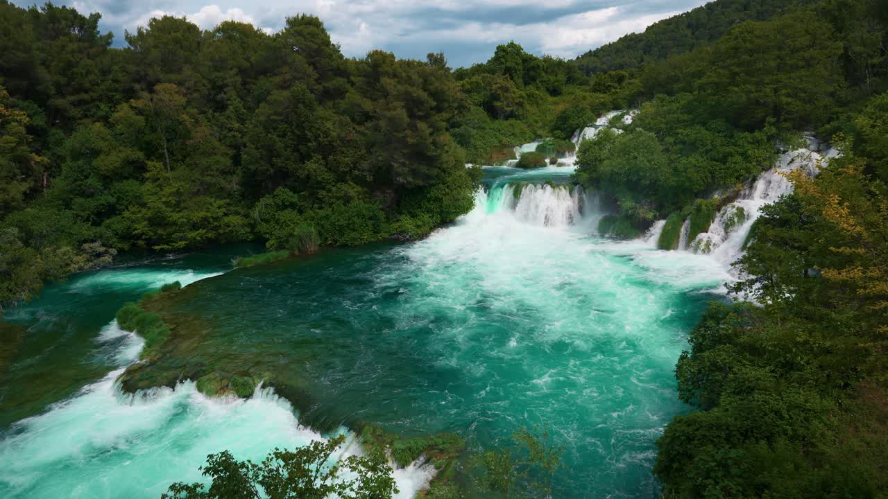Waterfalls and clear blue river running through lush forest at Krka National Park in spring, Croatia
