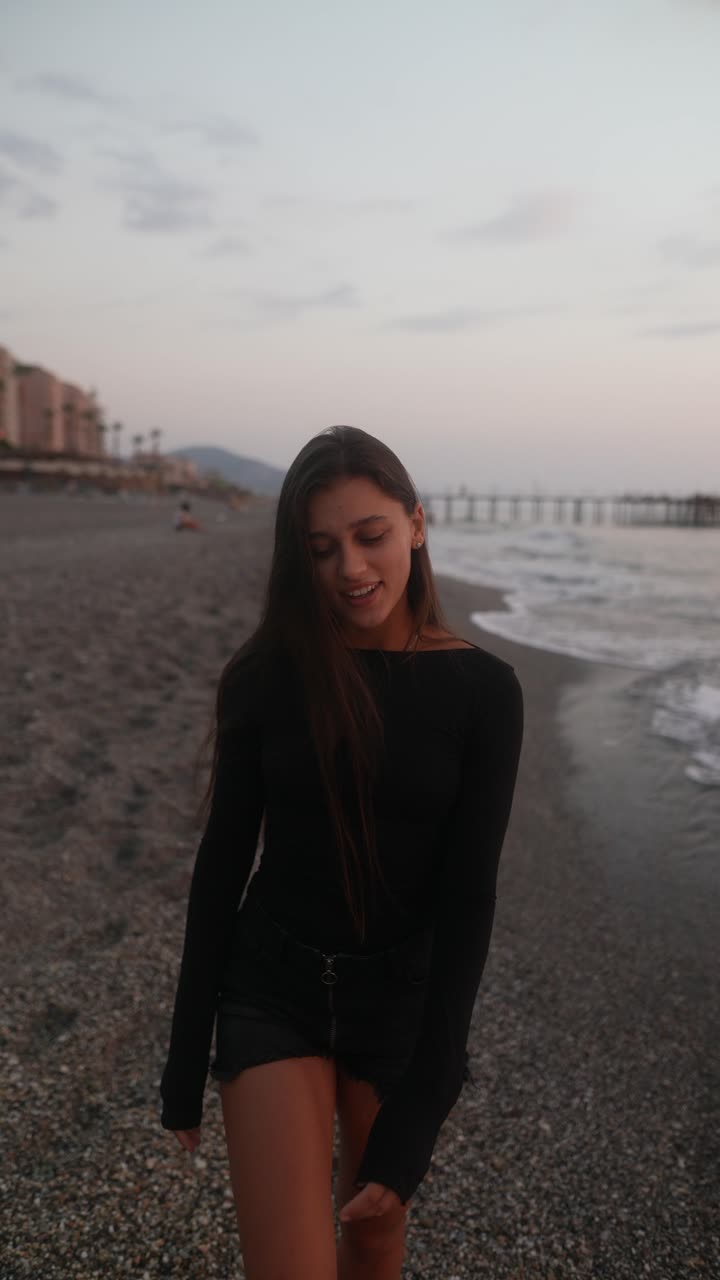 женщина гуляет по пляжу на закате