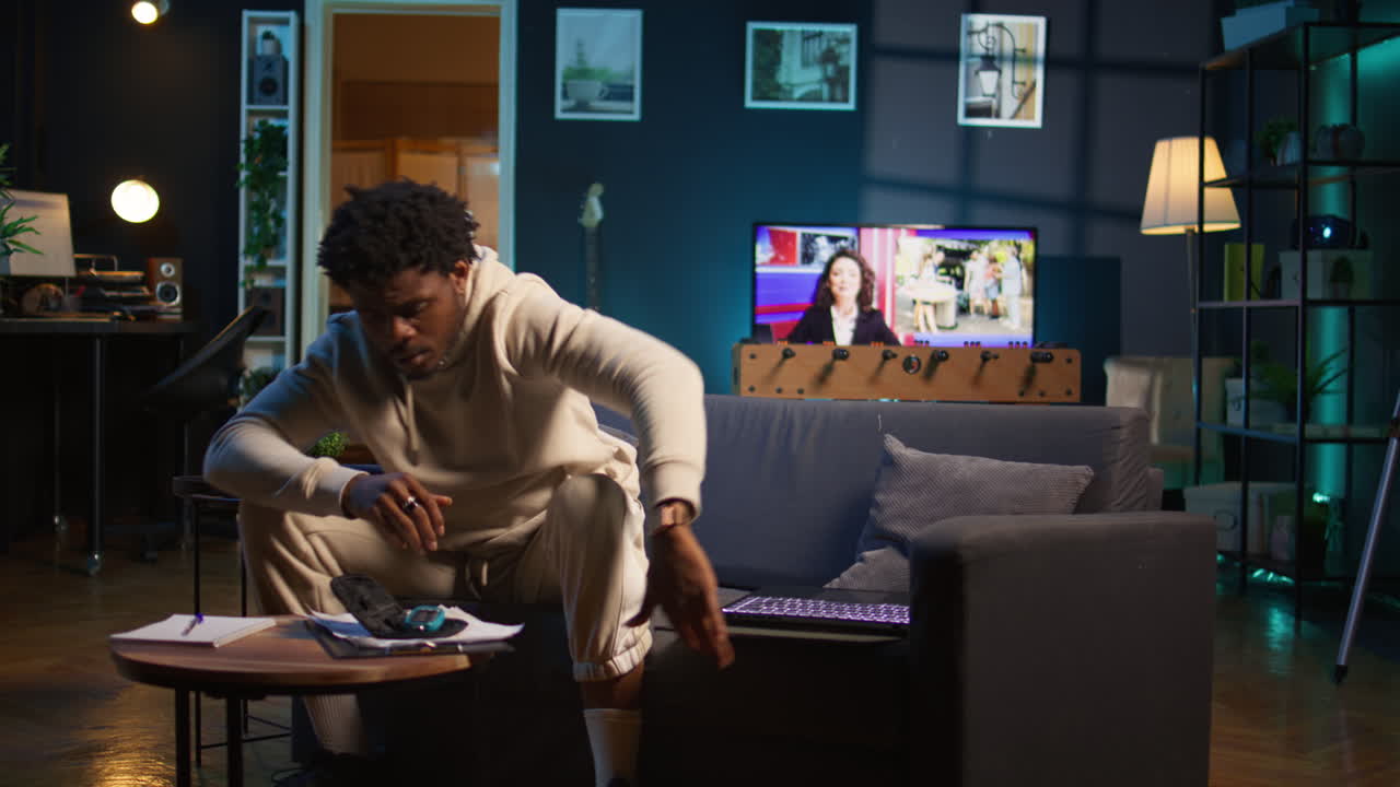 African american diabetic person working from home in his cozy apartment, using an insulin pen and measuring his glucose levels. Young adult with illness uses glucometer. Camera B.
