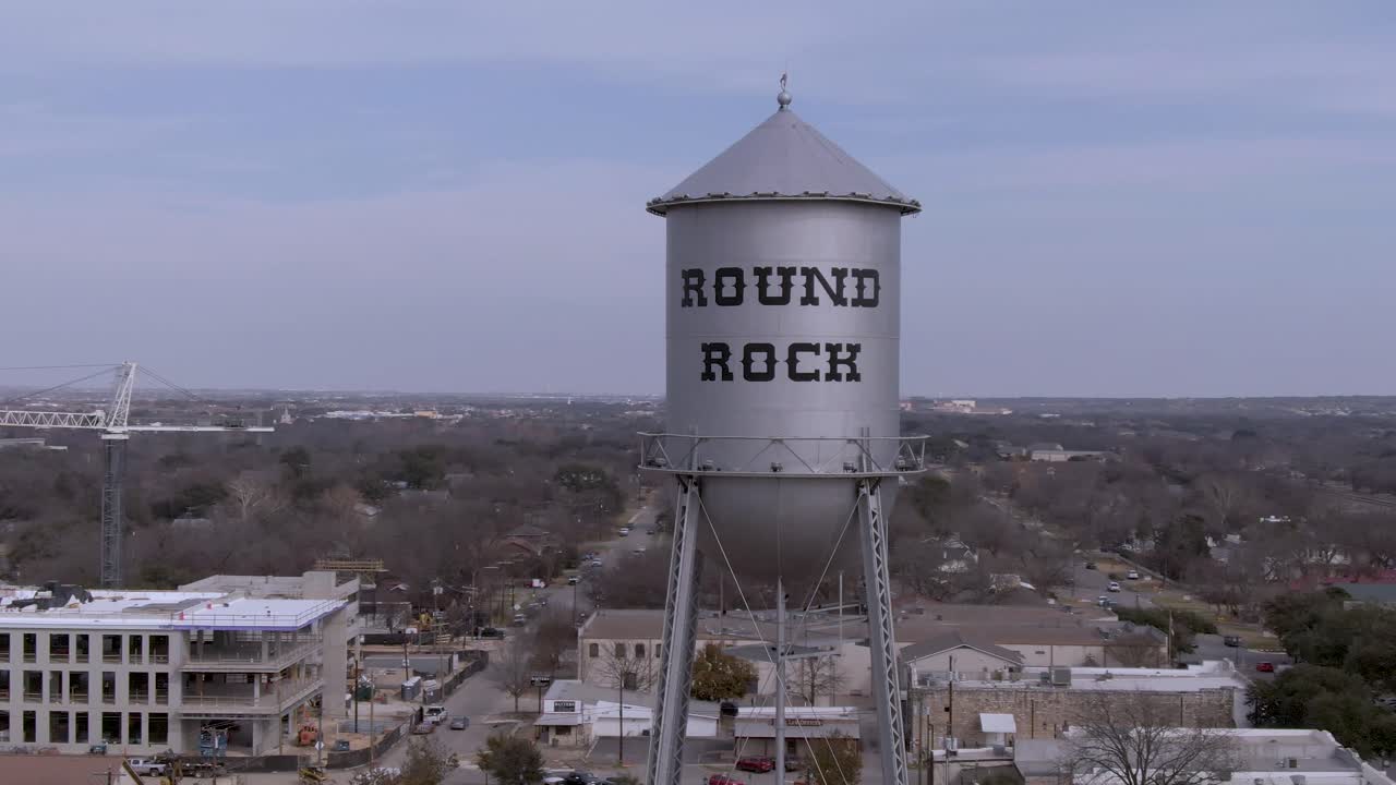 panorámica aérea alrededor de la torre de agua plateada en roca redonda, texas en un día soleado