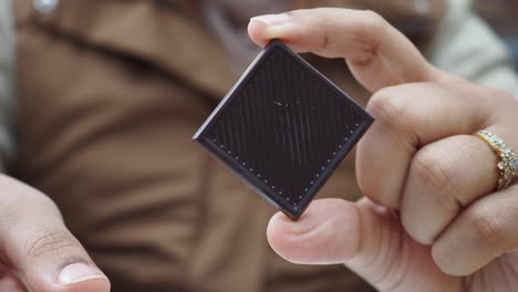 closeup of a person holding a dark chocolate bar