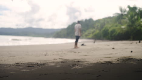 Turista-Caminando-Solo-En-La-Playa-Tropical-De-Arena-De-Costa-Rica-Con-Jungla-De-Palmeras-En-El-Fondo