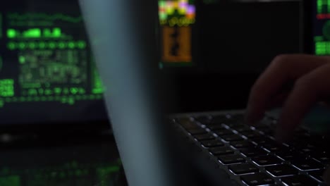 person typing in a technology center on a laptop, slider reveal close-up